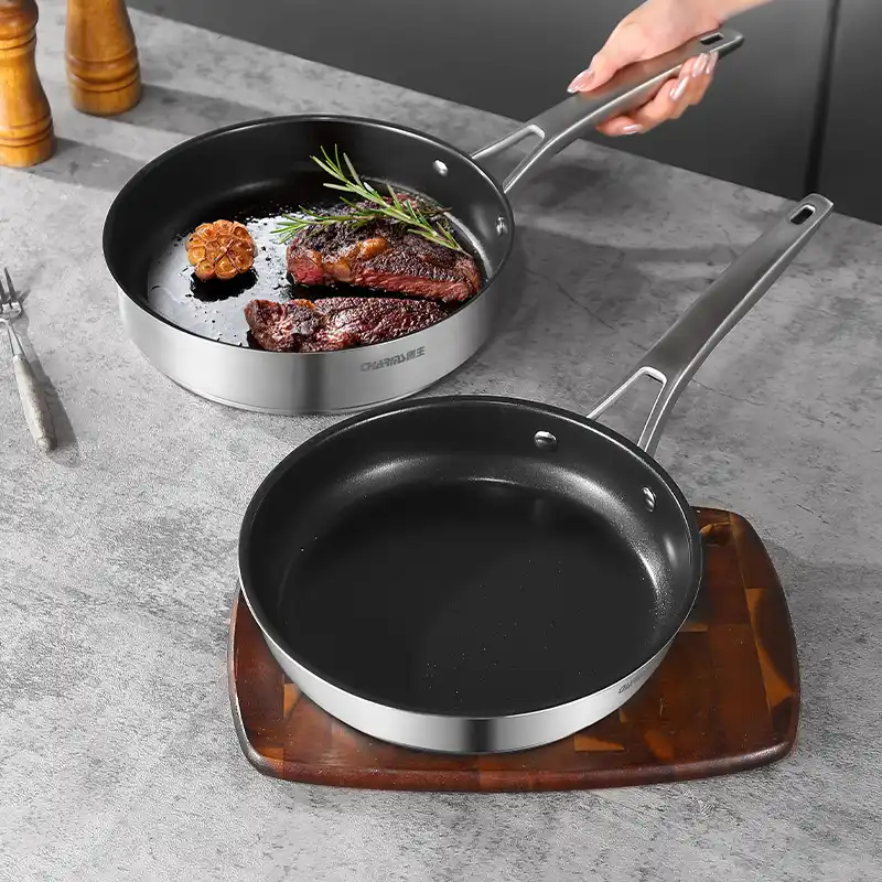 A person holds a frying pan filled with sautéed meat and colorful vegetables, ready for cooking.