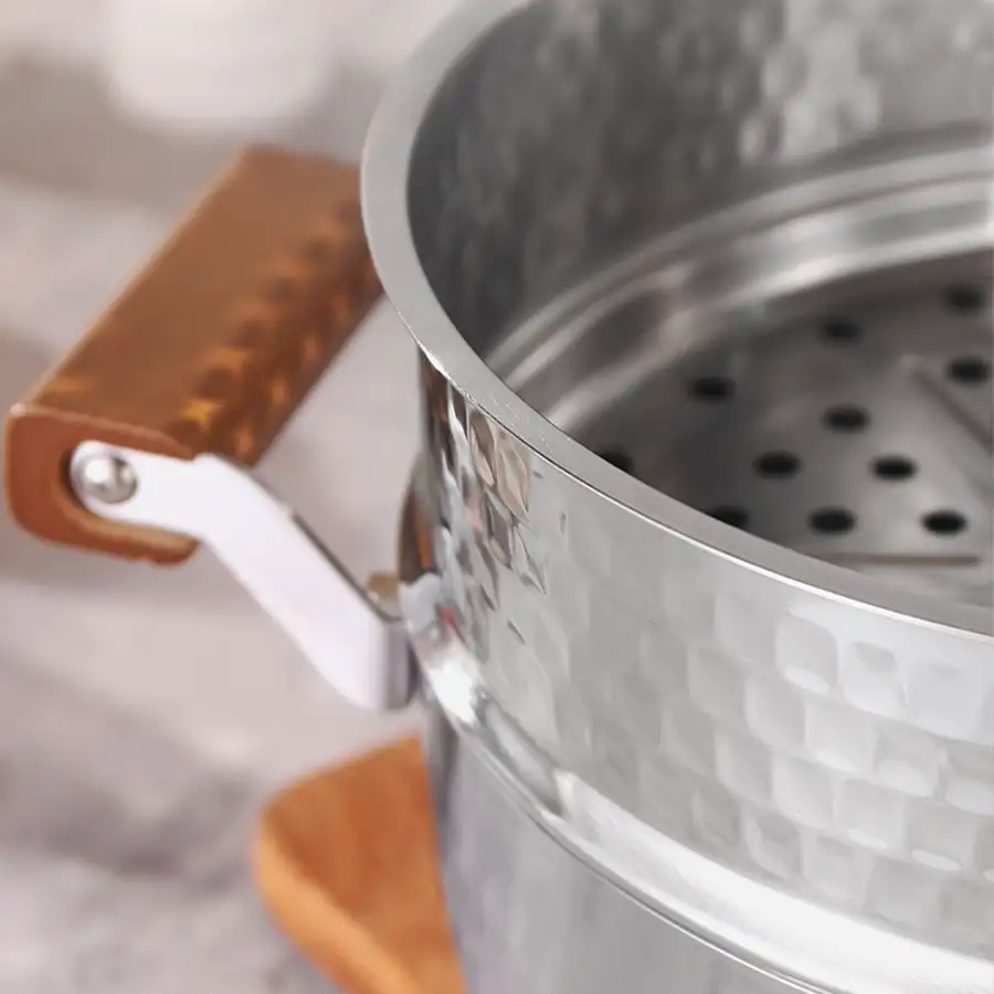 A shiny stainless steel pot featuring a warm wooden handle, perfect for cooking and serving meals.
