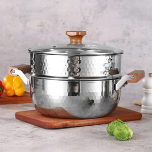 A stainless steel cooking pot featuring a wooden handle, positioned on a cutting board for easy access while cooking.