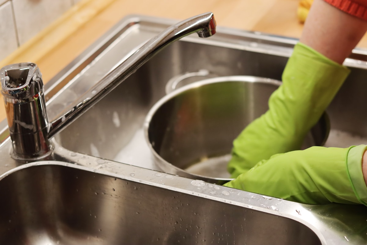 Stainless steel pan care routine showing proper hand washing drying and storage with pan protectors