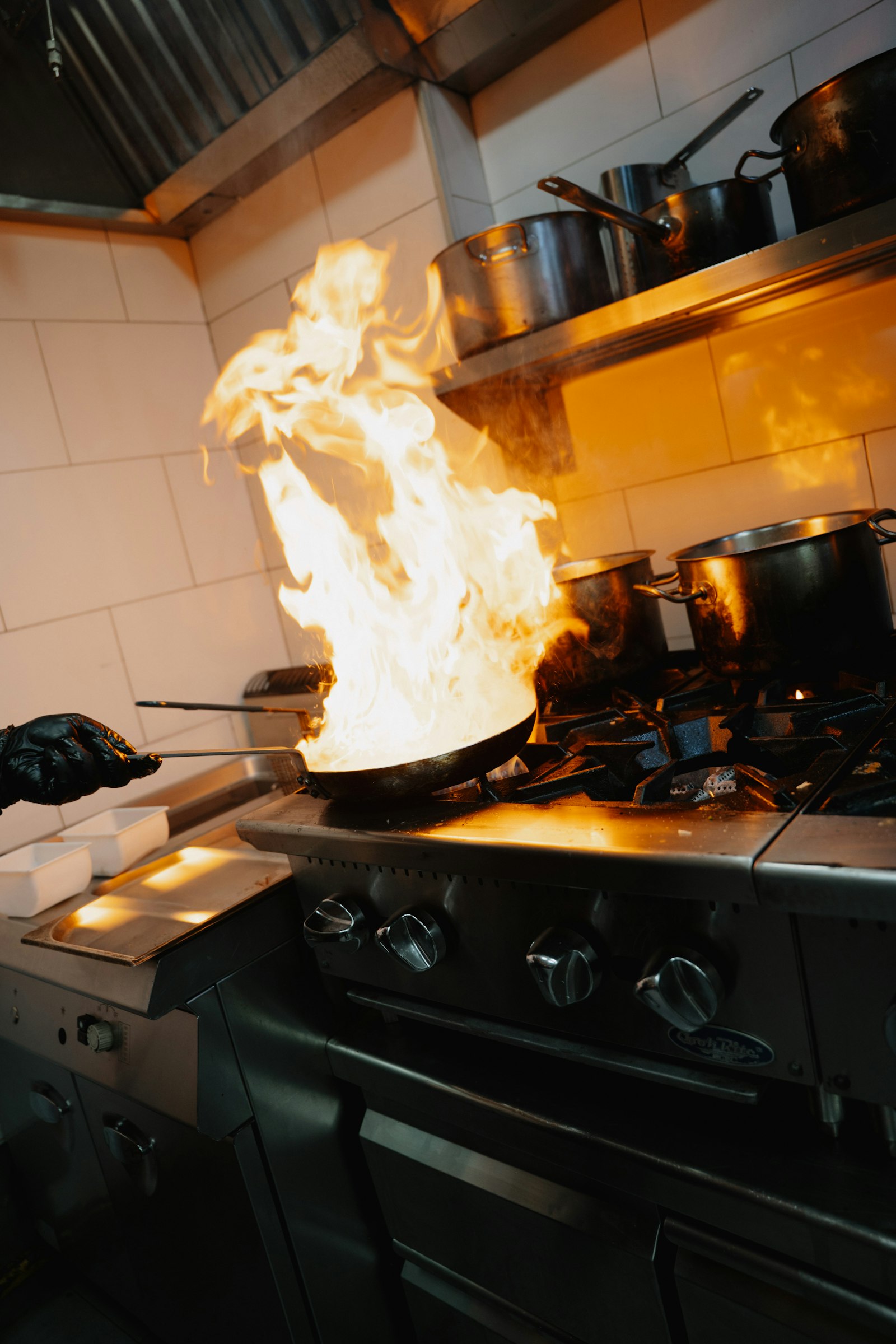 Professional chef cooking with stainless steel pan in commercial kitchen - 18/10 tri-ply cookware long-term durability in professional use