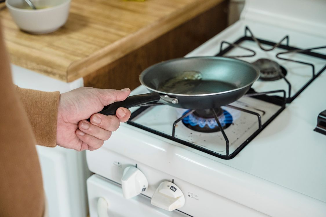 Stainless steel pan being seasoned with swirling oil - polymerized oil layer formation for non-stick surface