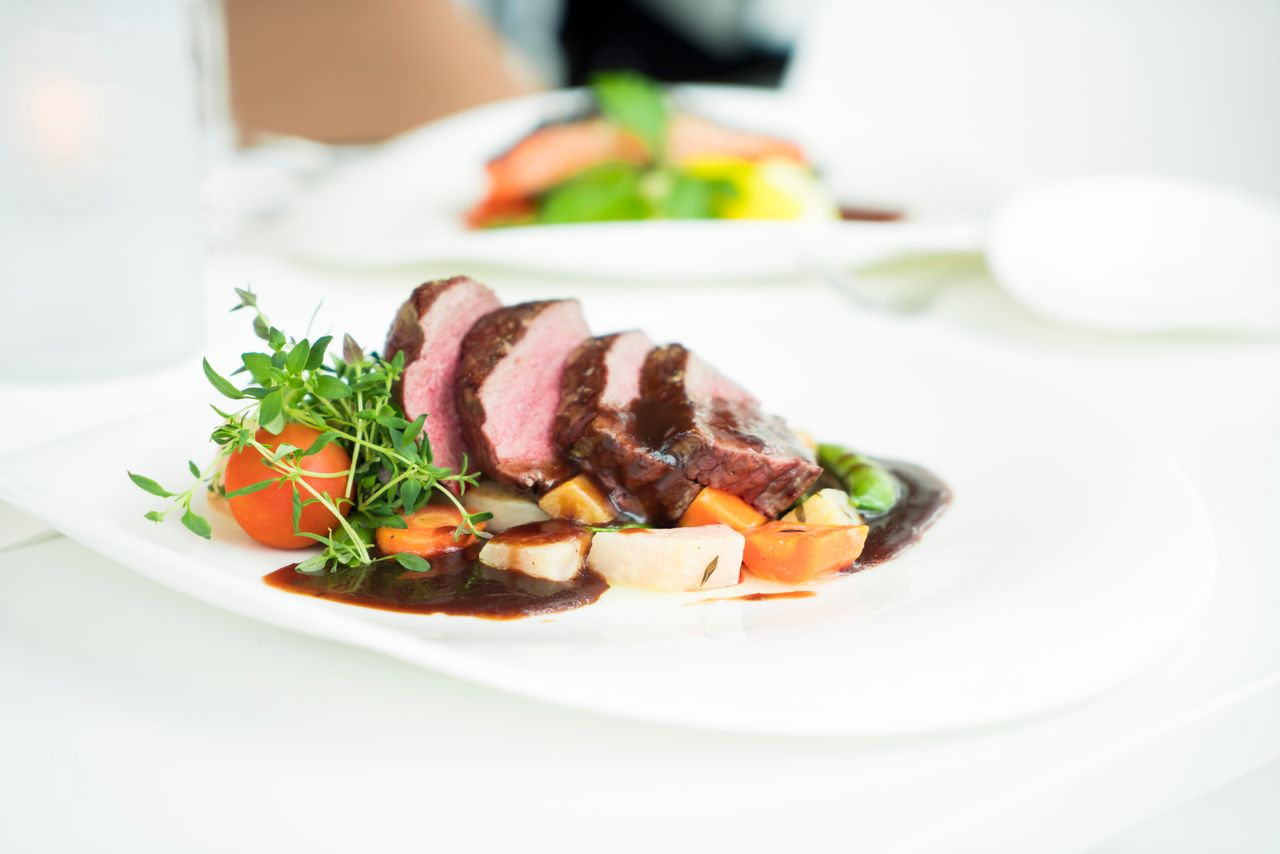 Sliced beef steak with rich pan sauce and fresh herbs - the finished result of the fond and deglazing technique
