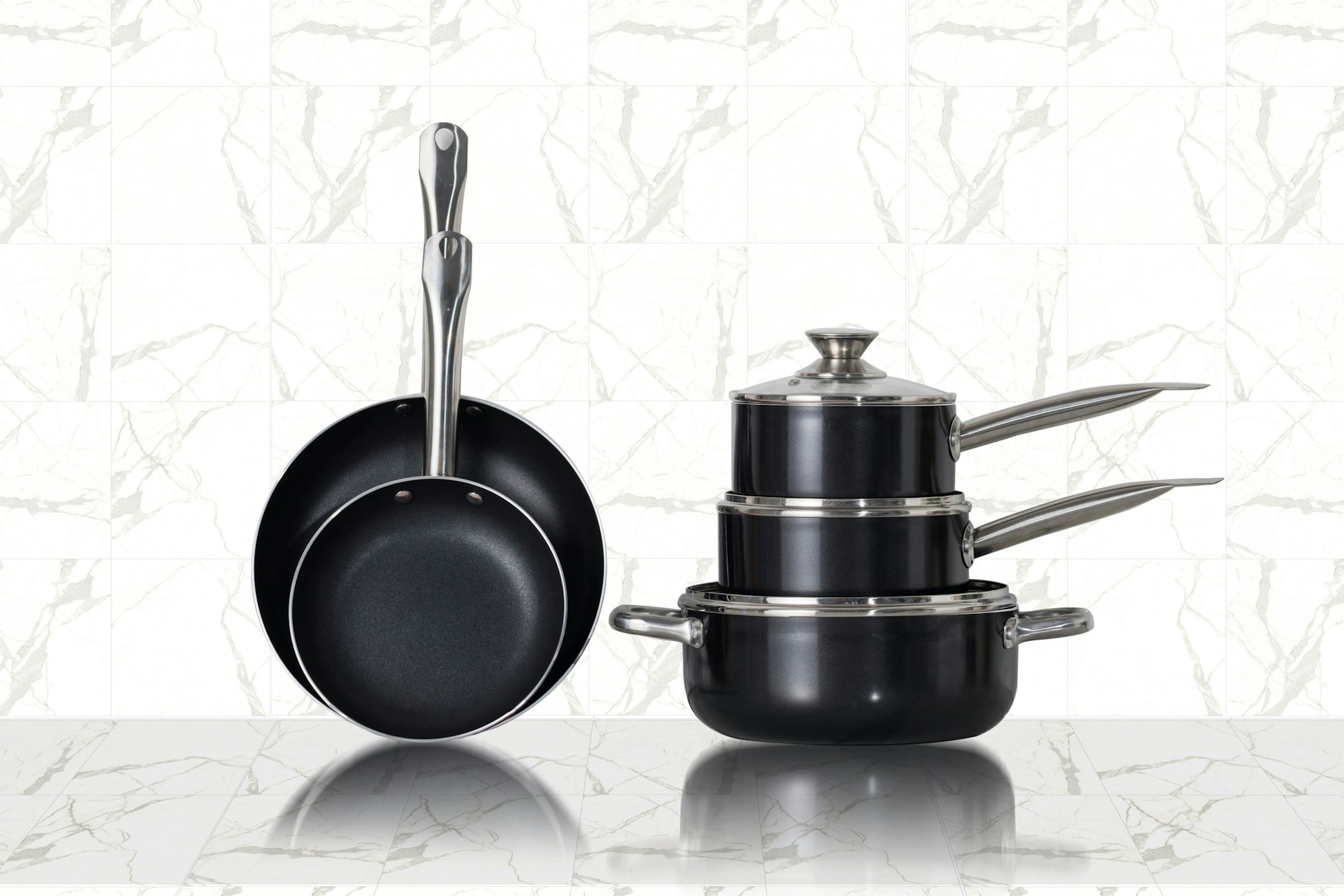 Stainless steel cookware set on kitchen counter - fully-clad pots and pans showing construction quality