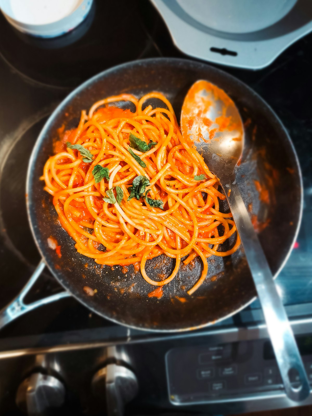 Tomato sauce simmering in a stainless steel pan - acidic foods and long cooking times increase nickel migration from 18/10 stainless cookware
