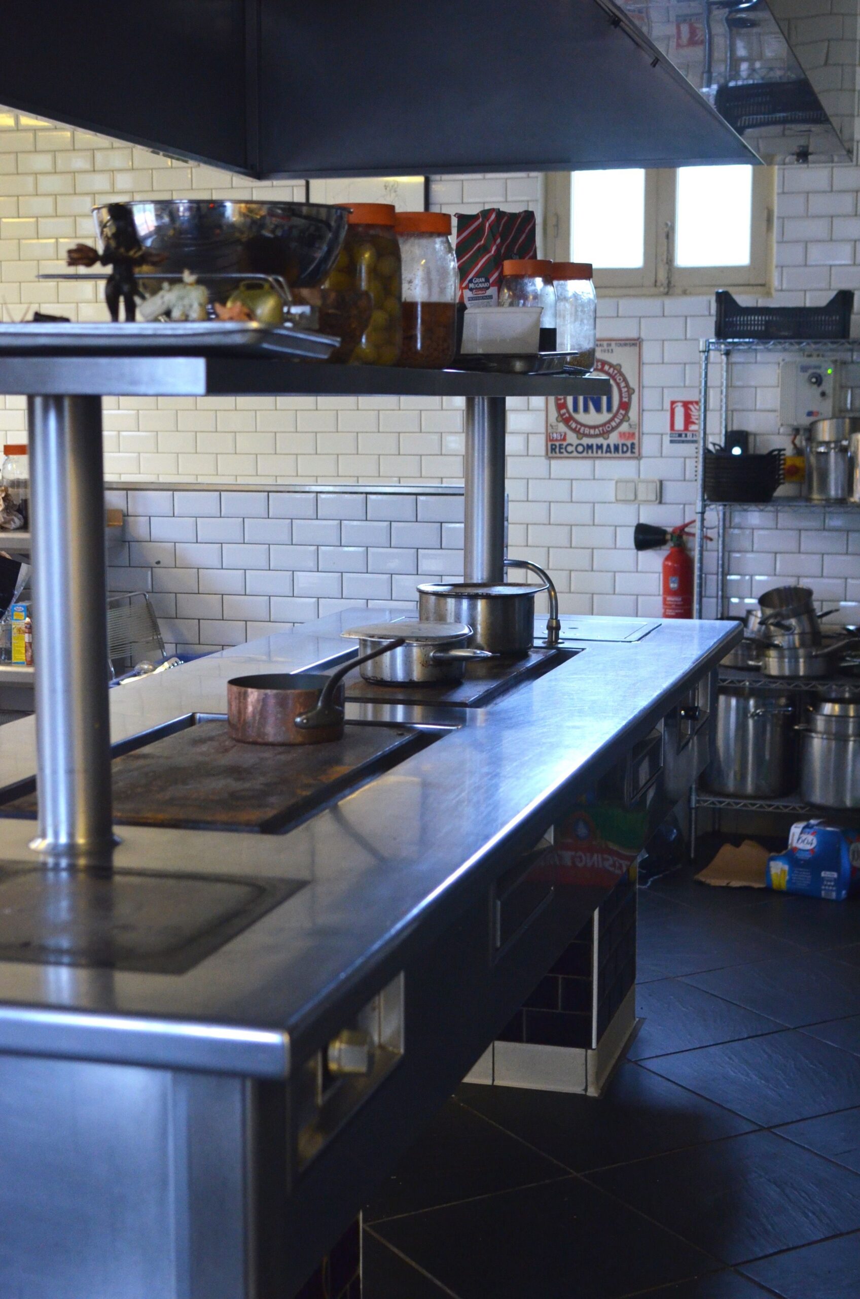 Empty commercial kitchen with stainless steel surfaces and professional cooking equipment - restaurant supply environment