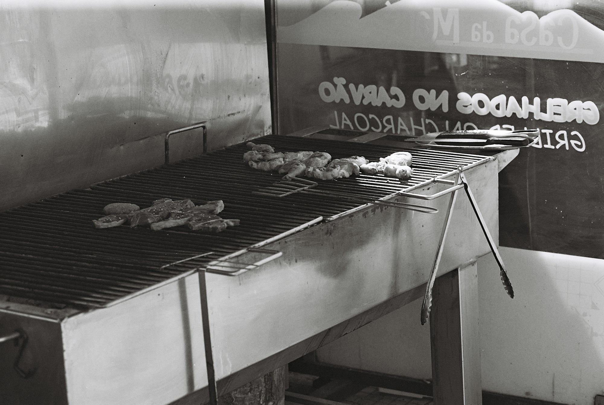 Stainless steel tongs in use at a busy commercial restaurant kitchen station