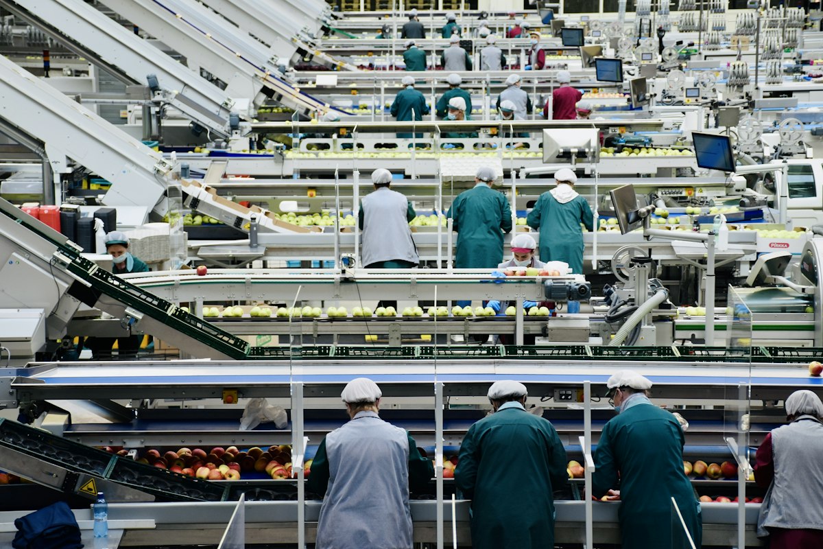 Quality control inspector examining cookware on factory production line - supplier verification process